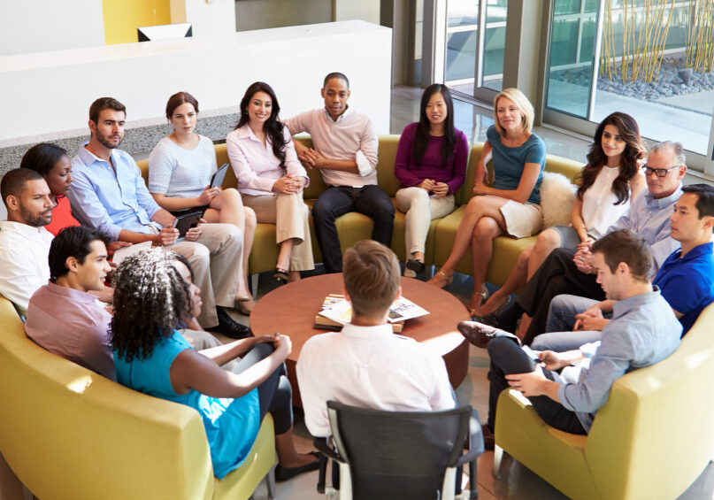 Multi-Cultural Office Staff Sitting Having Meeting Together